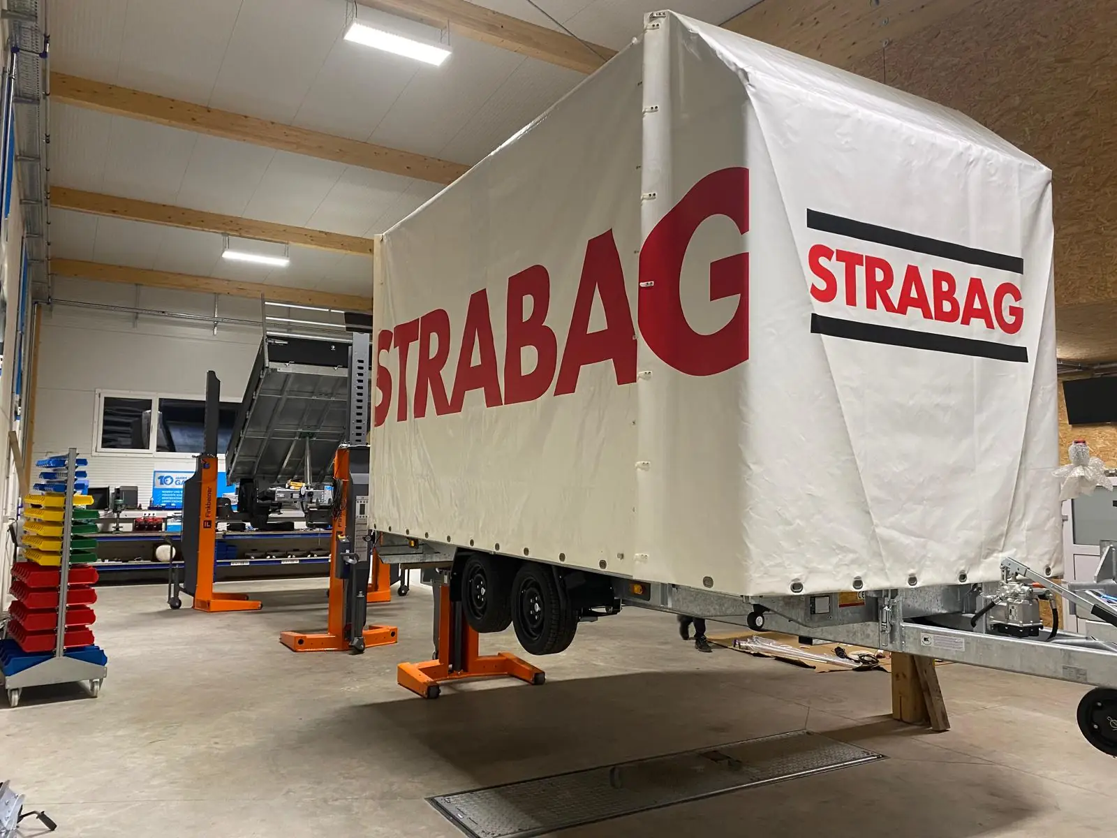 Planenanhänger auf Hebebühnen in der INN-KA Prüf- und Werkstatthalle